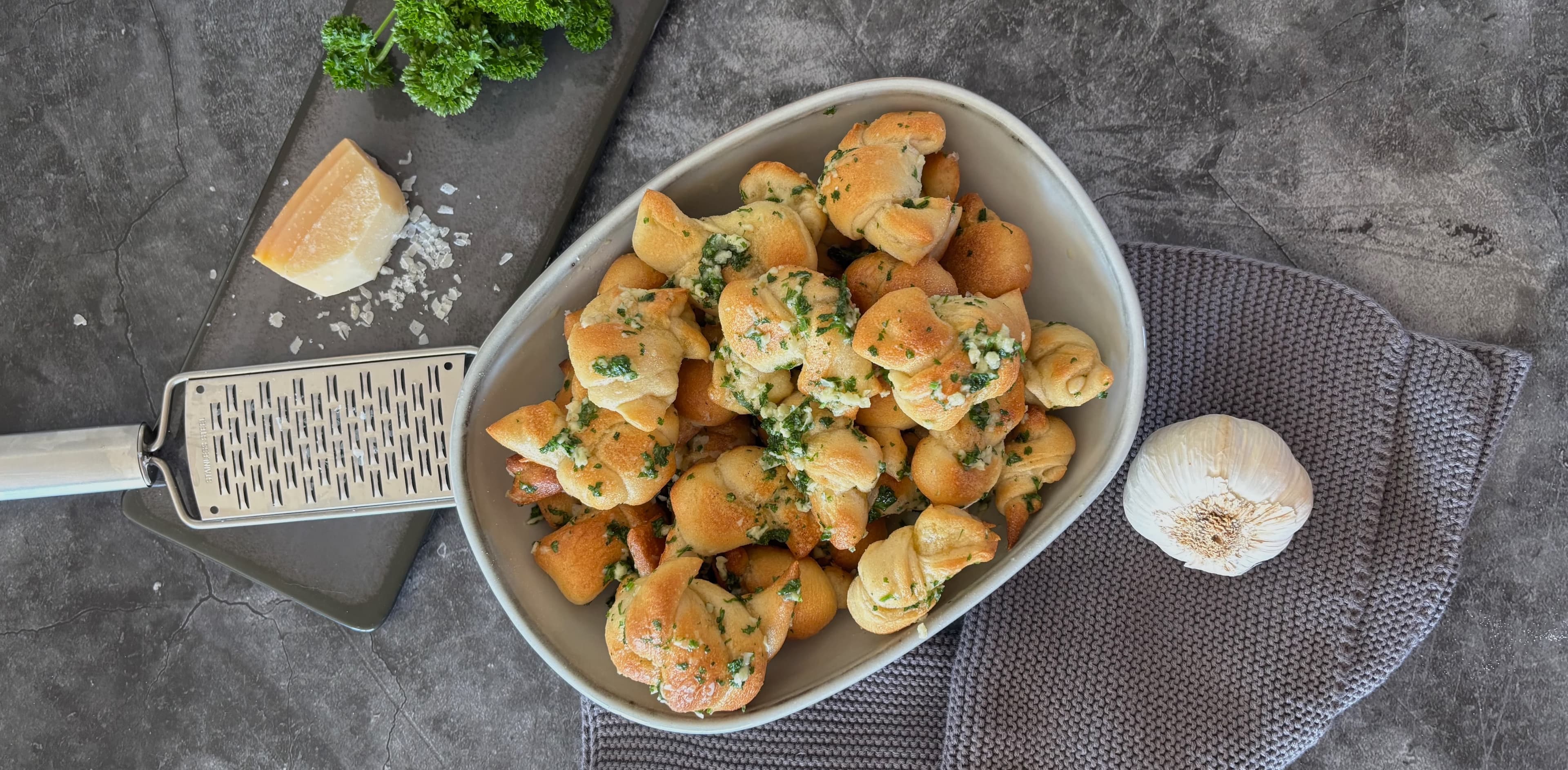 Frisch gebackene Pizza-Knoten mit Knoblauch Frisch gebackene Pizza-Knoten mit Knoblauch, Petersilie, Parmesankäse und Olivenöl