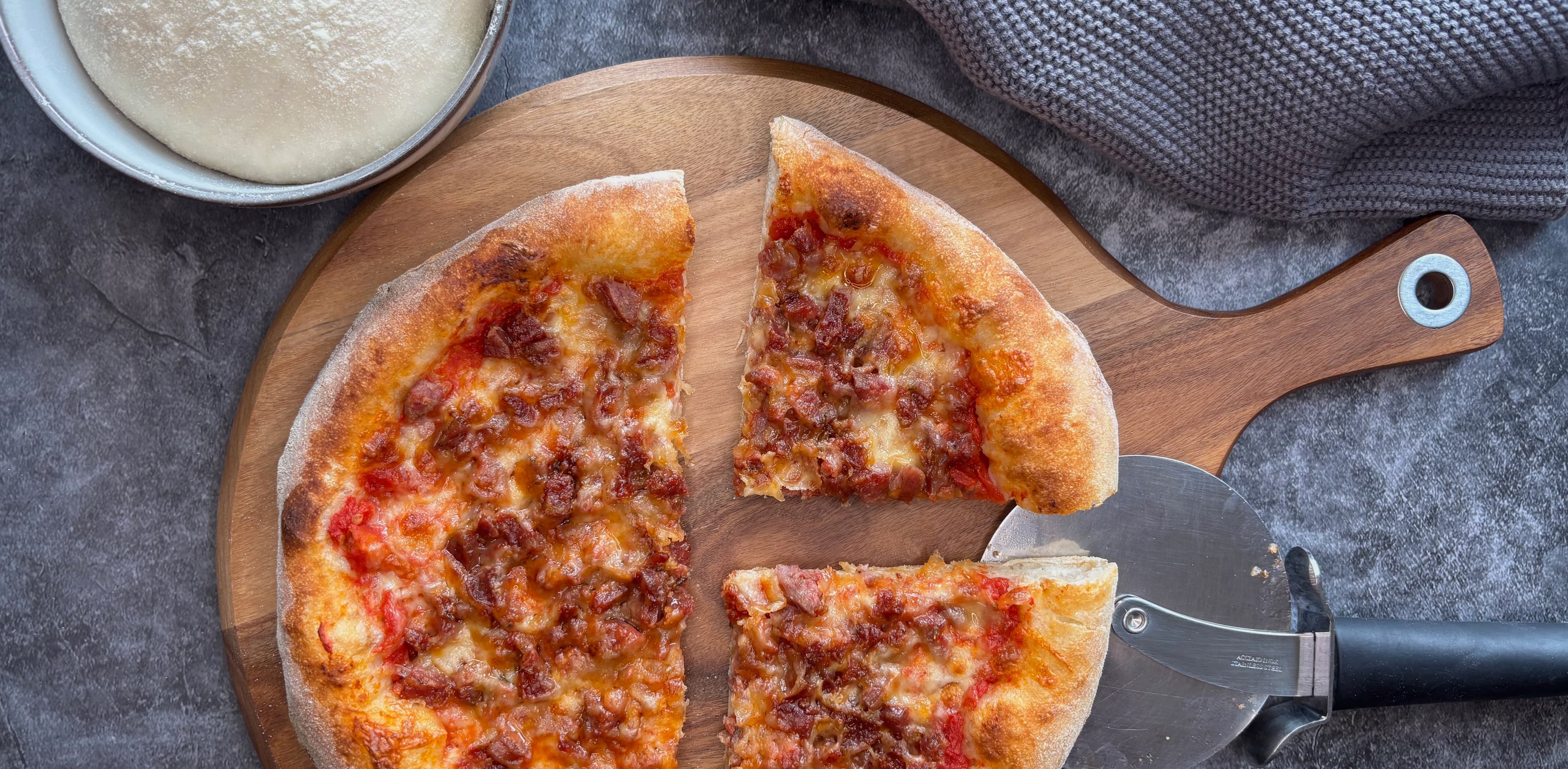 Frisch gebackene Pizza Salciccia auf einem Pizzastein